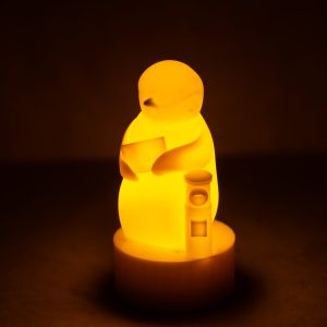 「旅ペンギン」のランプ・シリーズ、今回の新作。旅先から手紙を送ろうとしているところでしょうか？ 大事そうに抱き抱えた封筒には、封蝋が施されています。LEDキャンドルのゆらゆらとした光で、あなたの心の旅路を照らします。